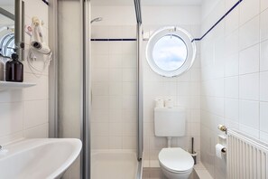 Un bagno con doccia, WC e lavandino.