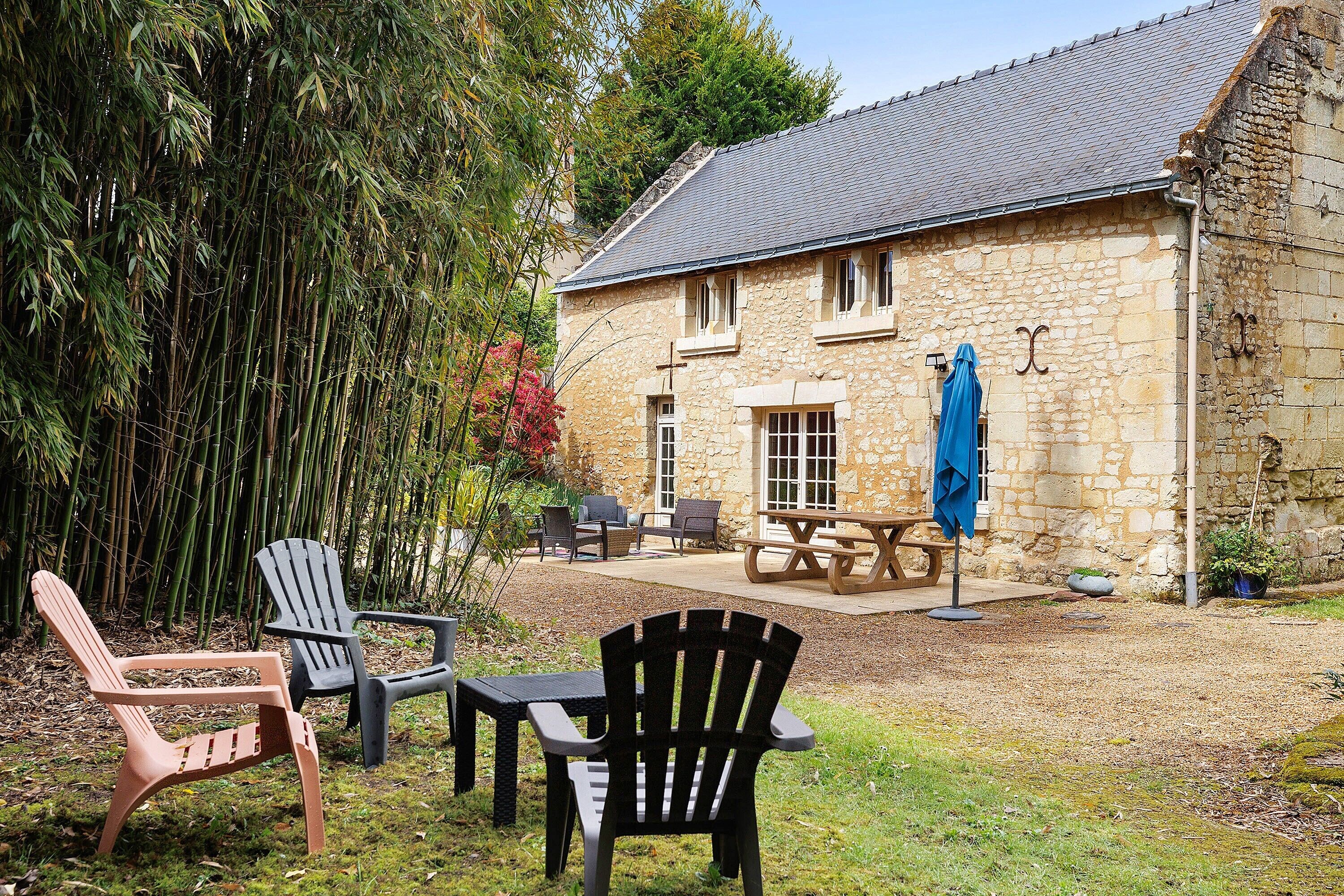 Un bâtiment en pierre doté d’un patio, d’un espace extérieur aménagé avec des sièges et d’une table couverte.