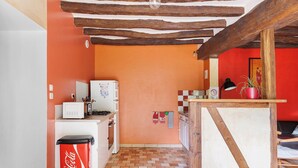A kitchen with a microwave, refrigerator, and a Coca-Cola cooler.