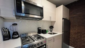 A modern kitchen with a gas stove, microwave, and stainless steel appliances. - Grand Upper West Side Suite, Sleeps 8+, Steps to Central Park (New York)