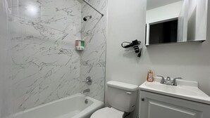 A bathroom with a bathtub, toilet, and sink. - Grand Upper West Side Suite, Sleeps 8+, Steps to Central Park (New York)