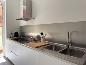 Eine moderne Küche mit Edelstahlgeräten, einer Spüle und einer Holz Arbeitsplatte.
