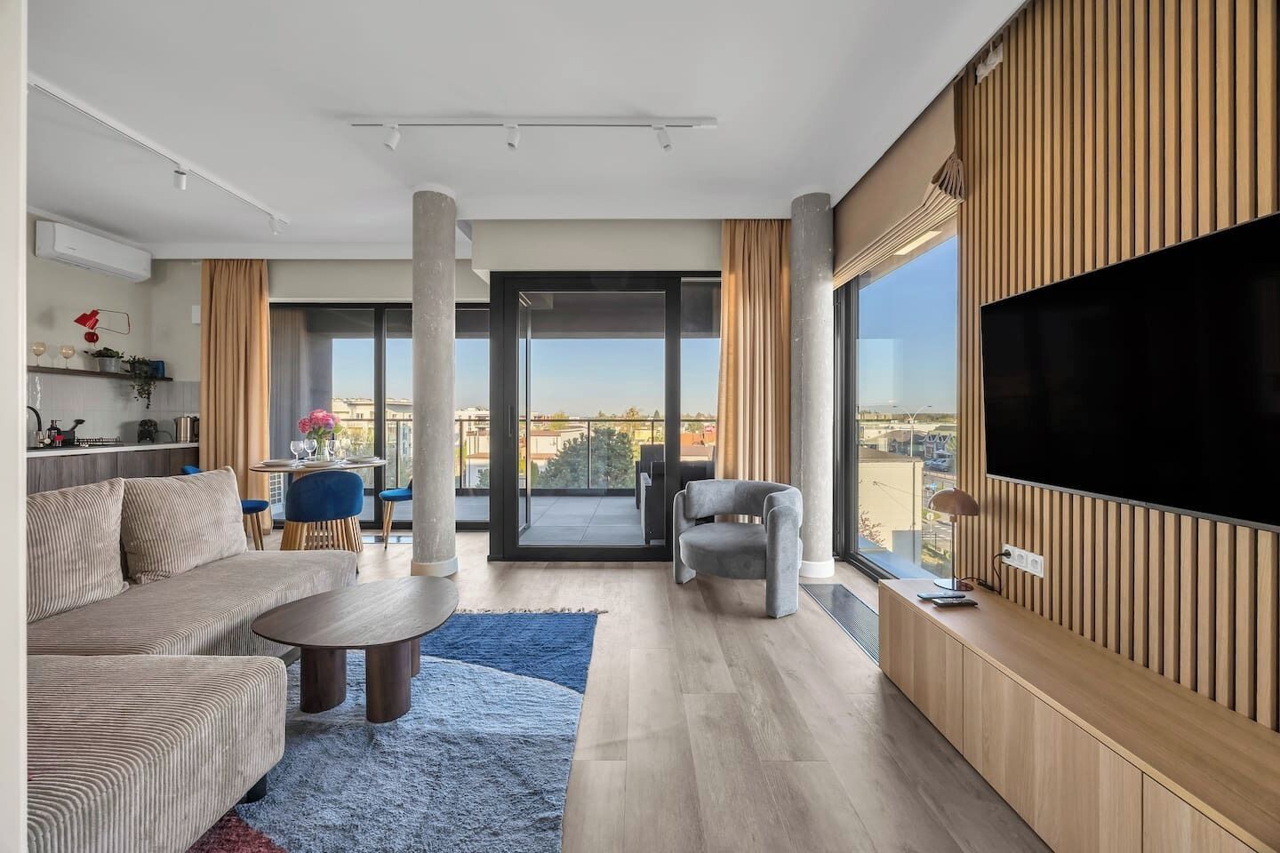 Un salon moderne avec un canapé, une table basse et un téléviseur fixé au mur.