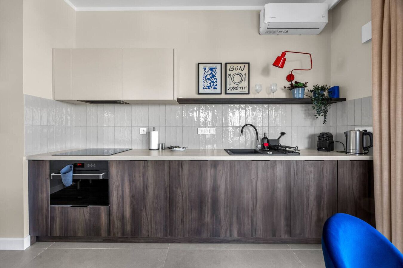 A modern kitchen with a built-in oven, a sink, and a coffee machine.
