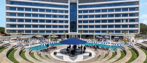 Un hôtel moderne doté d’une piscine centrale et d’un espace extérieur aménagé avec des sièges.