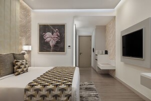 Una habitación de hotel moderna con una cama grande, un televisor montado en la pared y un cuadro de flamencos.