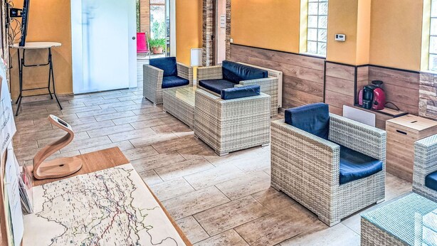 A modern lounge area with wicker furniture, a map, and a coffee machine. - Lovely apartment for 4 people with WIFI, TV and balcony (Finkenstein Am Faaker See)
