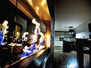 Eine moderne Küche mit Kochinsel, einem Essbereich mit dunklem Holztisch und einer sichtbaren Arbeitsplatte.