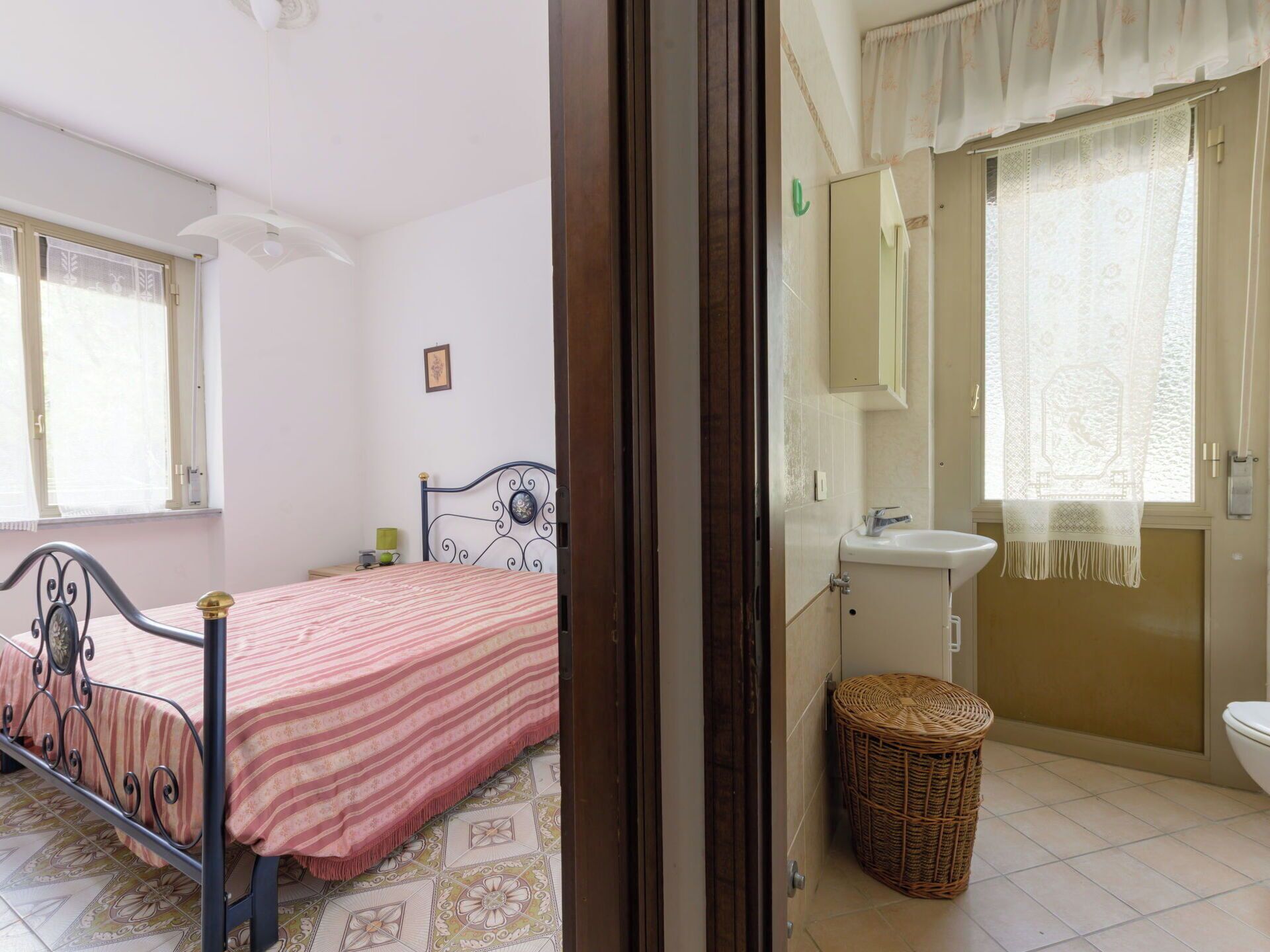 A bedroom with a bed, a bedside table, and a window.