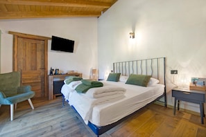 Une chambre à coucher avec un lit, un bureau, une chaise et un téléviseur.