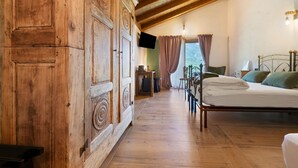 A wooden room with a bed, a television, and a window with curtains. - Le Rêve Guest Room - Zaya (Saint-Vincent)