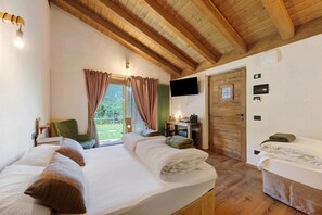 Een kamer met twee bedden, een bureau, een stoel, een televisie en een deur.