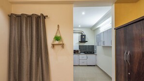 Une cuisine avec des meubles blancs, un four à micro-ondes et une cuisinière à gaz.