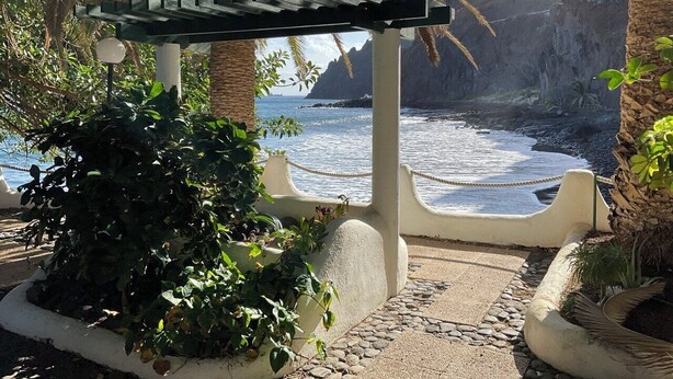 A coastal walkway with a pergola, plants, and a view of the sea and cliffs. - Oceanfront Playa Las Gaviotas – Private Beach Tenerife, Ocean Front Canarias 2 (Santa Cruz de Tenerife)