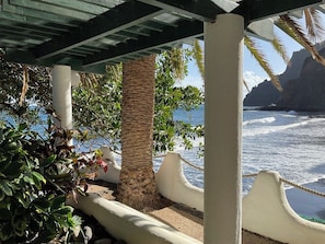 A coastal view with a wooden pergola, palm trees, and a rocky shoreline. - Oceanfront Playa Las Gaviotas – Private Beach Tenerife, Ocean Front Canarias 2 (Santa Cruz de Tenerife)