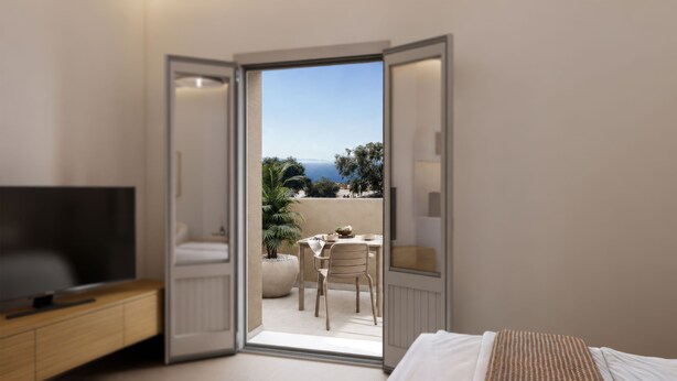 A bedroom with a TV, a bed, and a balcony with a table and chairs. - Terracotta Sunset Suites (Oia)