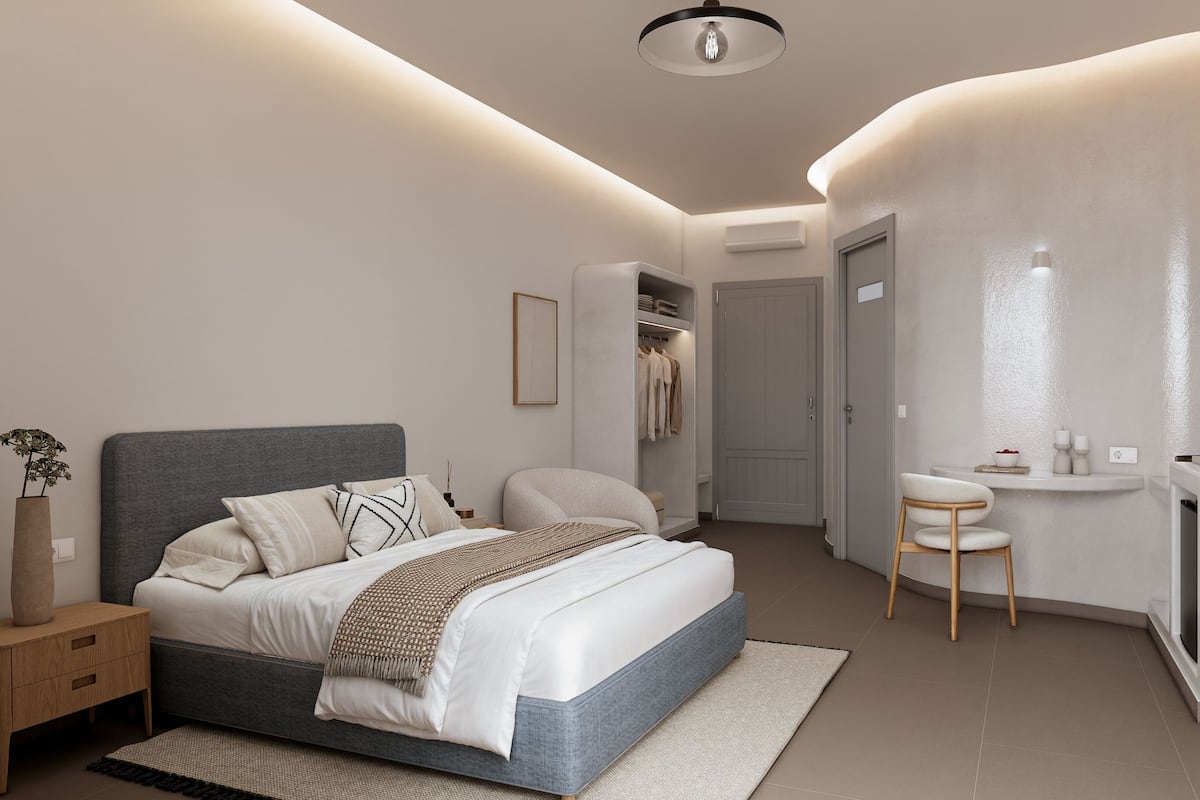 Ein modernes Schlafzimmer mit Bett, Nachttischen, einem Kleiderschrank, einem kleinen runden Tisch und einem fest installierten Waschbecken.