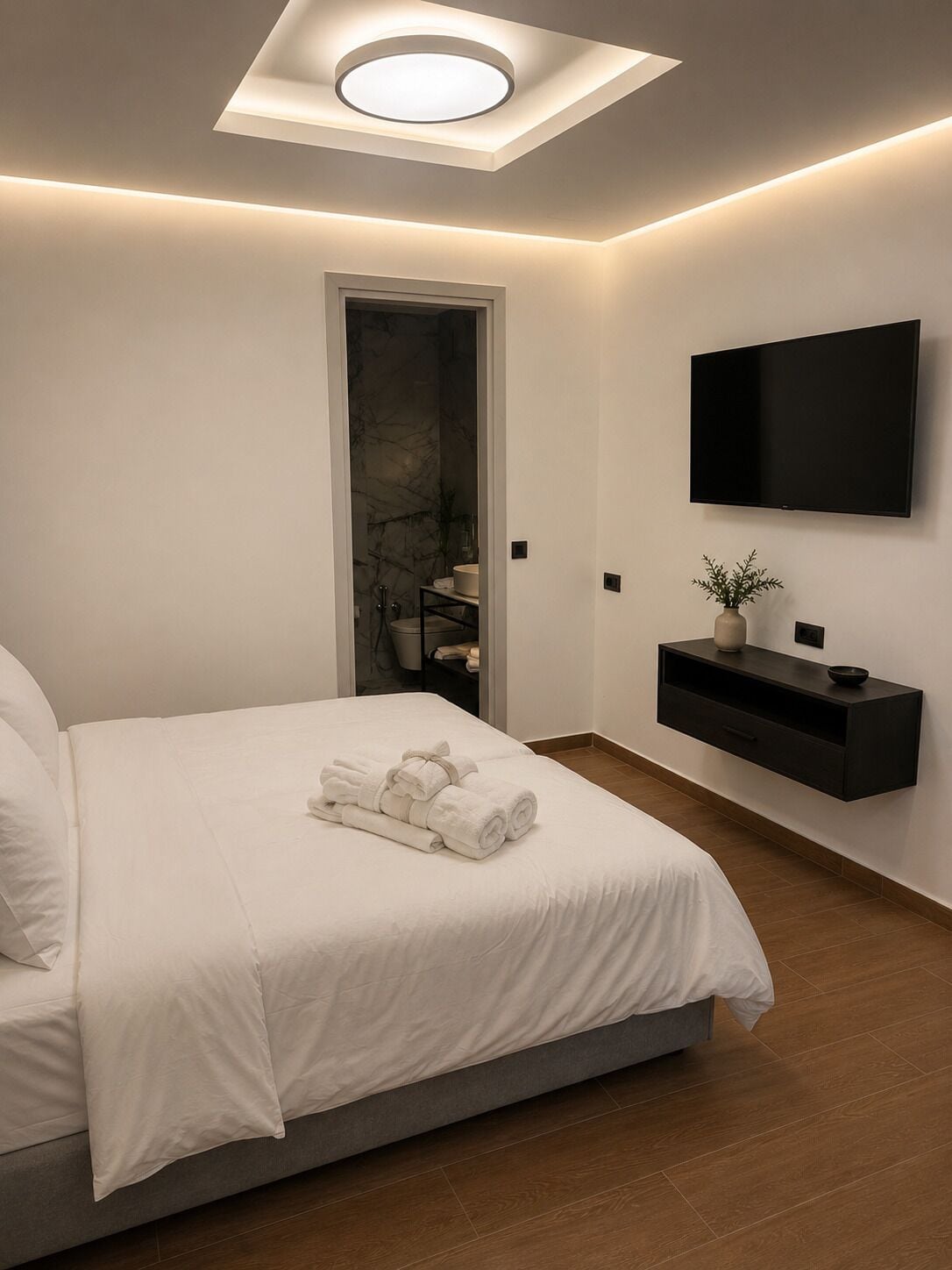 Een moderne slaapkamer met een bed, een televisie, een plank en een dakraam.