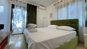 Ein Hotelzimmer mit Bett, Schreibtisch, Stuhl und einem fensterbepflanzten Fenster.