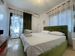 Ein Hotelzimmer mit Bett, Schreibtisch, Stuhl und einem fensterbepflanzten Fenster.