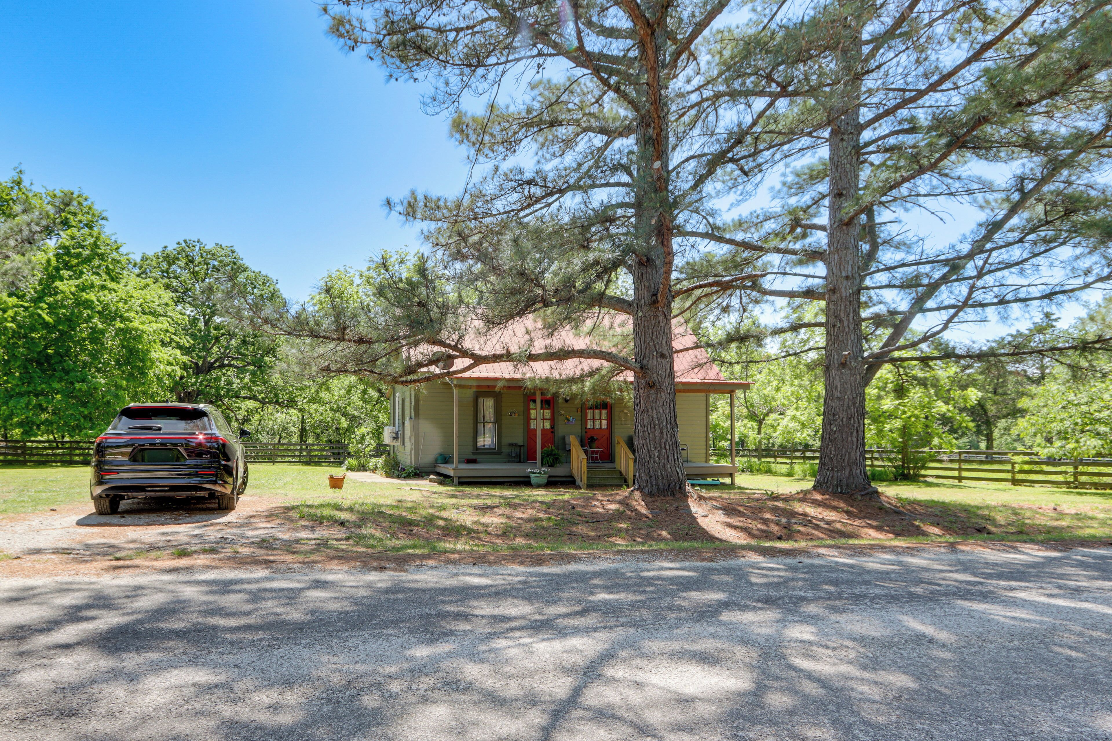 A house with a porch, a driveway, and a car parked in front.