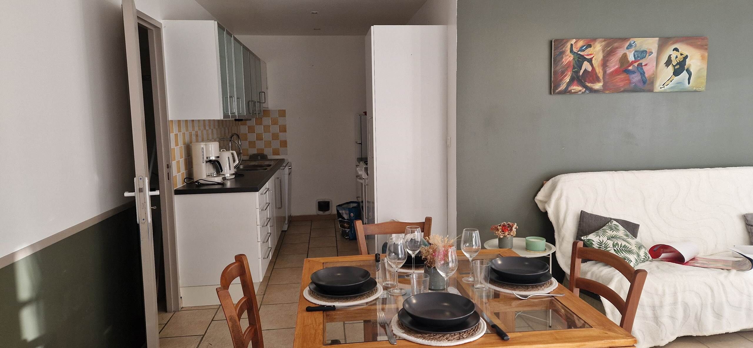Un espace de vie compact comprenant un coin repas, une kitchenette et un canapé.