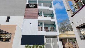 A modern hotel building with multiple balconies, a prominent sign, and a gated entrance. - Super Deluxe Room Neelam Hotel (Bareilly)
