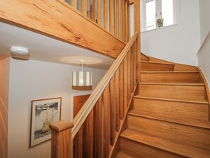 A wooden staircase with a handrail, a hanging light fixture, and a framed picture on the wall. - The Old China Shop (Ludlow)