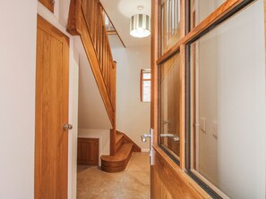 A wooden staircase leading to a landing with a door and a window. - The Old China Shop (Ludlow)