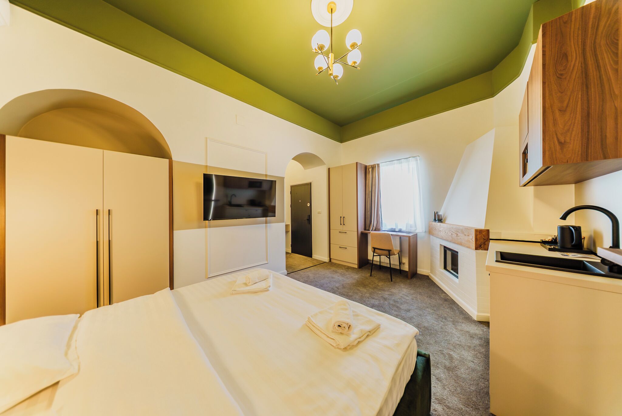 Une chambre d’hôtel équipée d’un lit, d’une télévision, d’un bureau et d’une kitchenette.