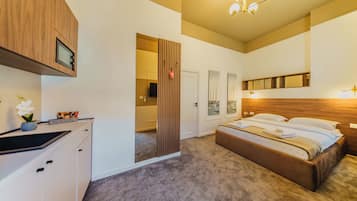 Una camera da letto con un letto, un armadietto in legno, uno specchio e una porta che dà su un'altra stanza.