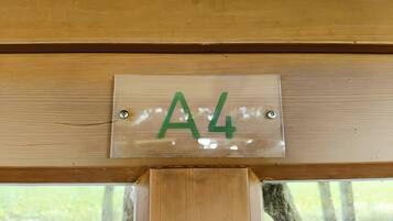 Eine Holztür mit einer Metallschildern, auf der 'A4' steht, und zwei sichtbaren Schrauben.