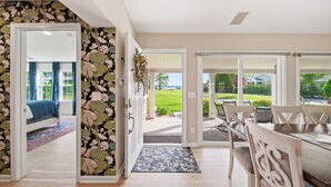 Un espace de vie ouvert comprenant un coin salon avec un lit, une table à manger et une vue sur le jardin.