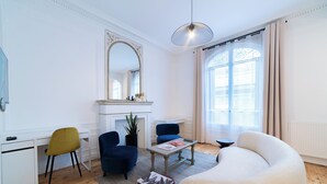 A modern living room with a fireplace, a large mirror, and a comfortable seating area. - Finestate Coliving Dupleix (Paris)