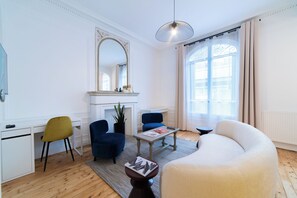 A modern living room with a fireplace, a large mirror, and a comfortable seating area.