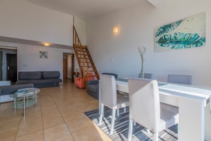 A modern living room with a sofa, coffee table, dining table, chairs, and a staircase. - Apartment with sea view in Crikvenica - ideal for 2-4 persons, with pool (Crikvenica)