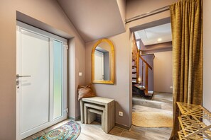A hallway with a door, a mirror, a bench, and a staircase. - Apartment -Sorayas Welt- direkt hinter dem Deich mit allen Annehmlichkeiten (Neufeld)