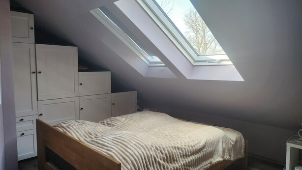 A bedroom with a skylight, a bed, and a wardrobe. - Apartment -Sorayas Welt- direkt hinter dem Deich mit allen Annehmlichkeiten (Neufeld)