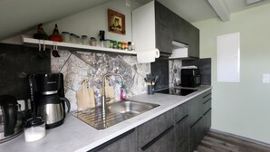 A modern kitchen with a stainless steel sink, a coffee maker, and a microwave. - Apartment -Sorayas Welt- direkt hinter dem Deich mit allen Annehmlichkeiten (Neufeld)