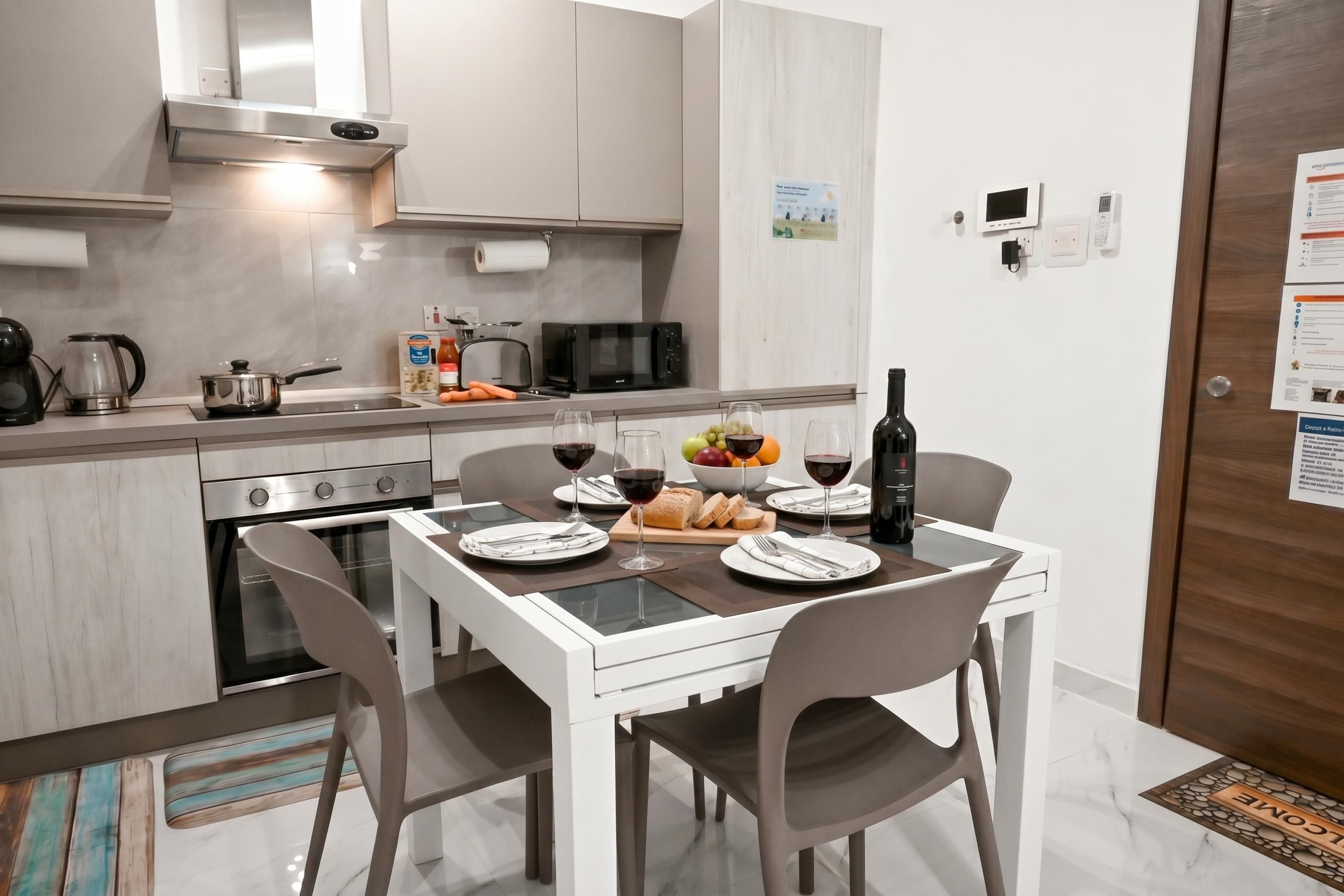 A modern kitchen with a dining area, equipped with a stove, oven, microwave, and a small refrigerator.