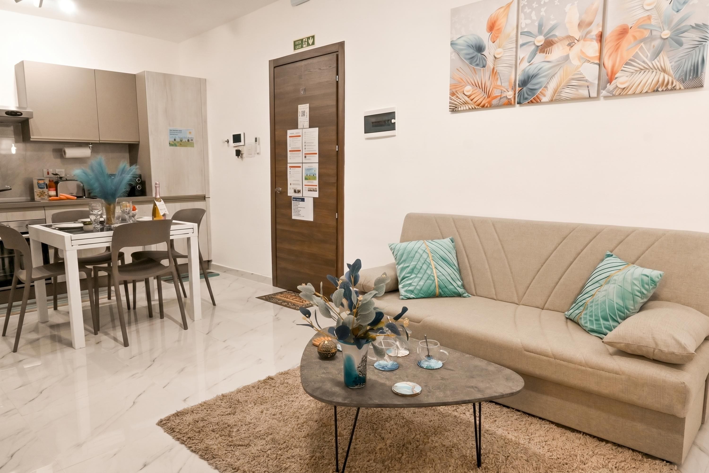 A modern living room with a sofa, coffee table, and dining area.