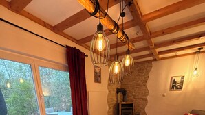 Un comedor con una mesa de madera, sillas y lámparas colgantes.