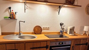 Una cocina con un fregadero, estufa y armarios de madera.
