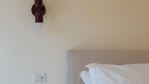 Een slaapkamer met een bed, toilet en een wandlamp.