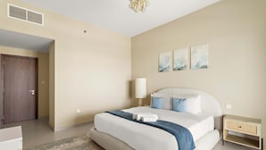 A bedroom with a bed, bedside table, lamp, and artwork on the wall. - Silkhaus Ajwan 1BD Mamsha Beach Access (Abu Dhabi)