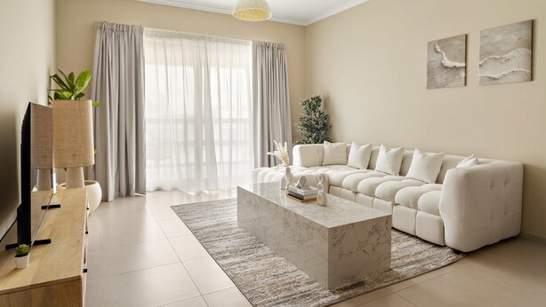 A modern living room with a sofa, a coffee table, a TV stand, and a large window with curtains. - Silkhaus Ajwan 1BD Mamsha Beach Access (Abu Dhabi)