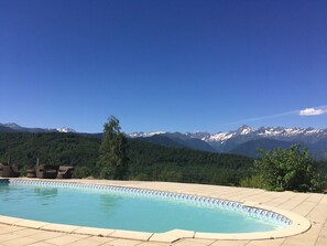 Une piscine avec vue sur des montagnes enneigées.