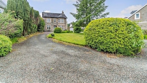 A stone house with a gravel driveway, surrounded by well-maintained hedges and trees. - Dunoon - Sleeps 17 - Group Retreat With Parking (Dunoon)