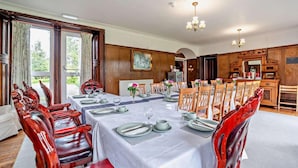 A dining room with a long table set for a meal, wooden chairs, and a chandelier. - Dunoon - Sleeps 17 - Group Retreat With Parking (Dunoon)