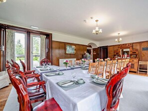 A dining room with a long table set for a meal, wooden chairs, and a chandelier. - Dunoon - Sleeps 17 - Group Retreat With Parking (Dunoon)